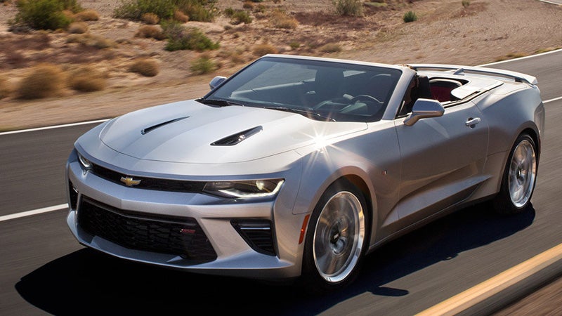 A silver Chevrolet Camaro driving on the highway in the desert